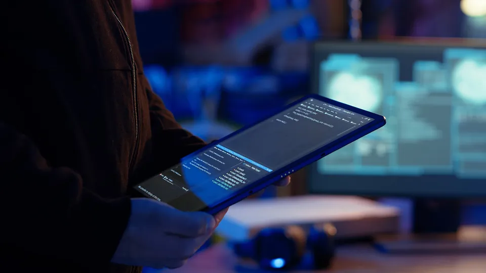 A person with a tablet showing a map in blue evening light