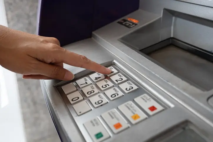 A finger on an ATM keypad