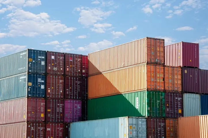 Stacked shipping containers under a blue sky
