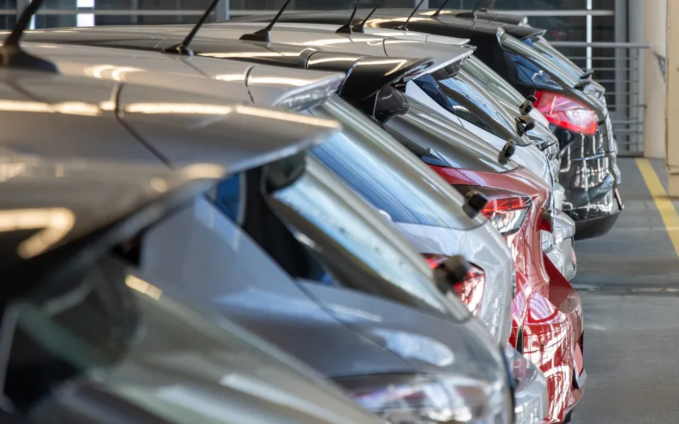 Row of parked rental cars, side mirrors in close-up